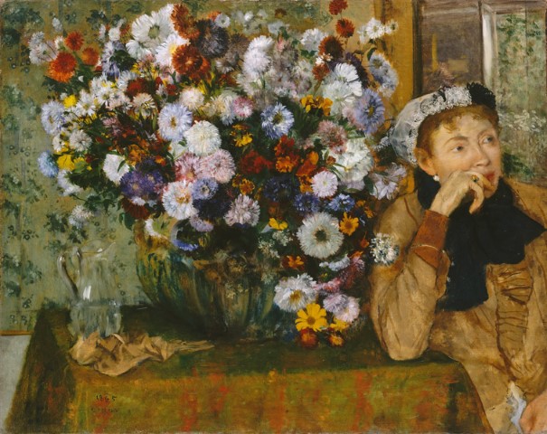 Женщина, сидящая рядом с вазой с цветами